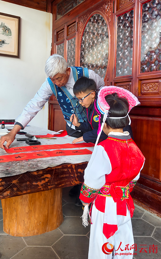 何继东指导孙子写春联。人民网记者 符皓摄