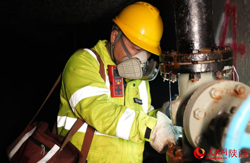 邹伟君对阀门进行细致检查。人民网记者 邓楠摄